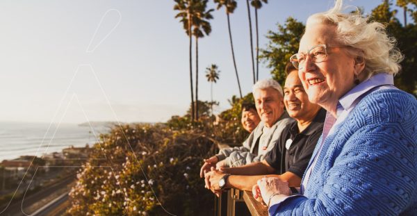 Four residents standing, smiling, looking out at the ocean