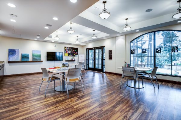 A large open room with two small tables and chairs, and a large window