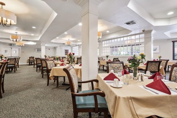 A large seating area with lots of tables and chairs. There are lots of windows, and the space is very open.