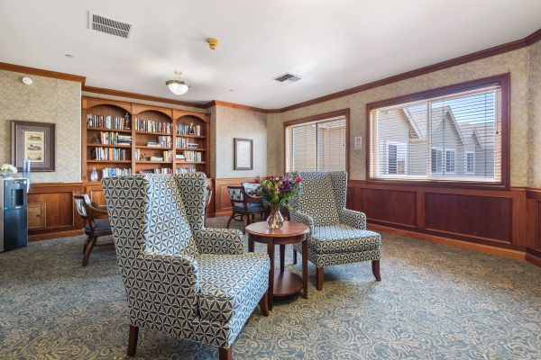 A reading area with two chairs, a small table, and a built-in bookshelf.