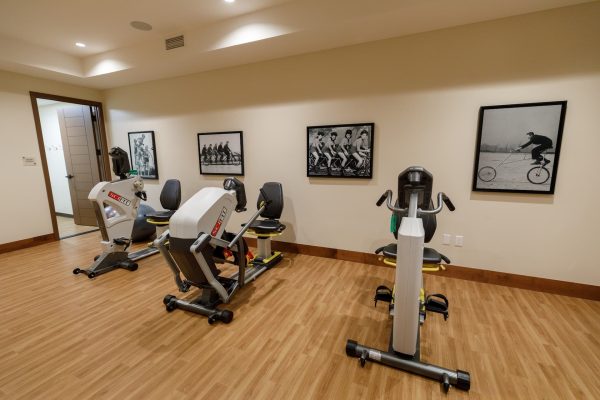 A workout room with three workout machines