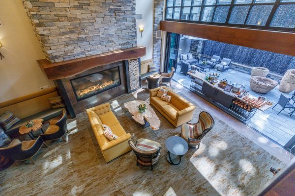 The lobby, with yellow couches, a stone fireplace, and an outdoor seating area