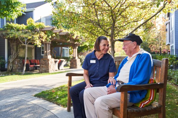A resident and an employee sitting and chatting outside