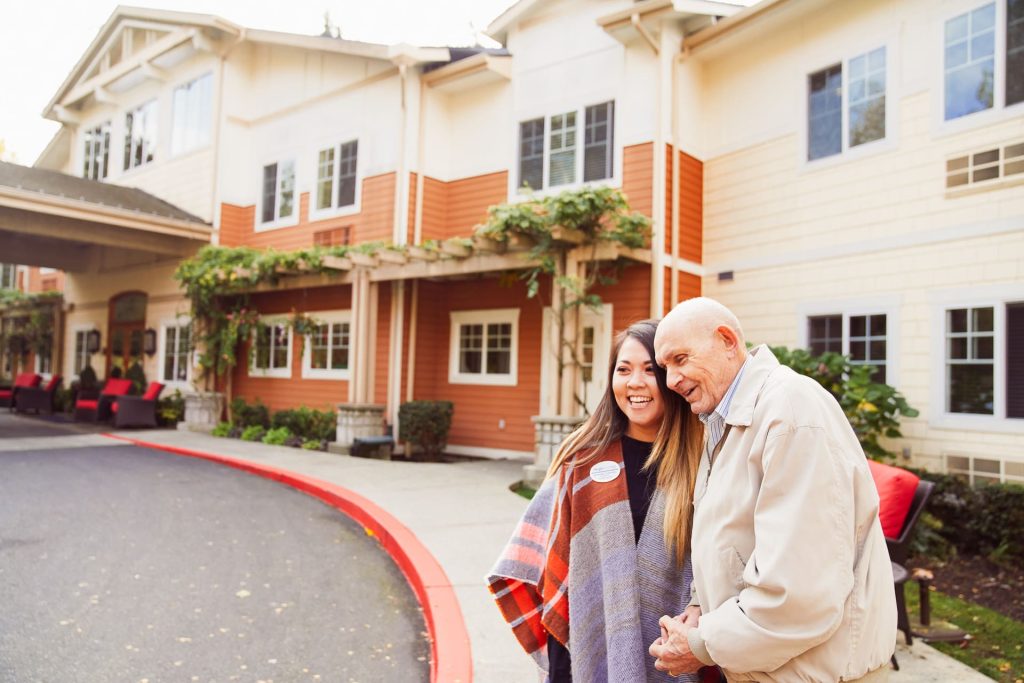 A resident and an employee standing outside of Aegis Living