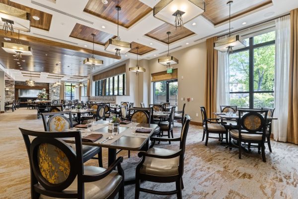 A large dining area with tables, chairs, and windows