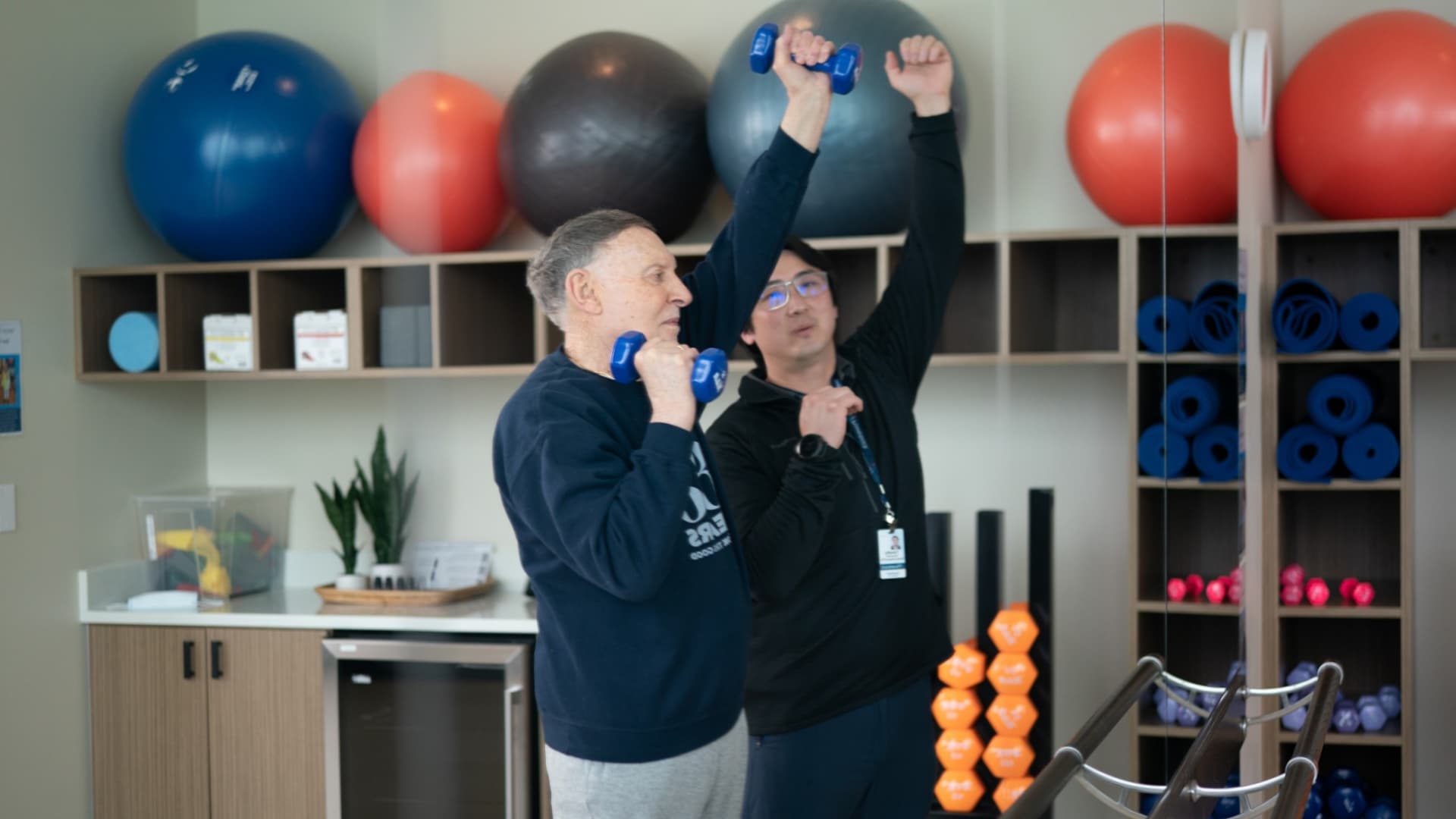 A resident working out with an employee