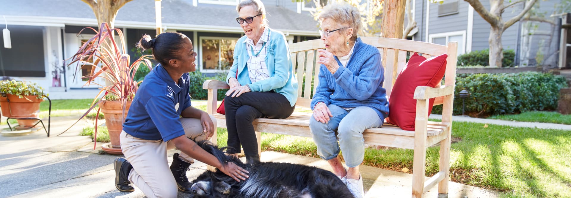 Residents and an employee petting a dog