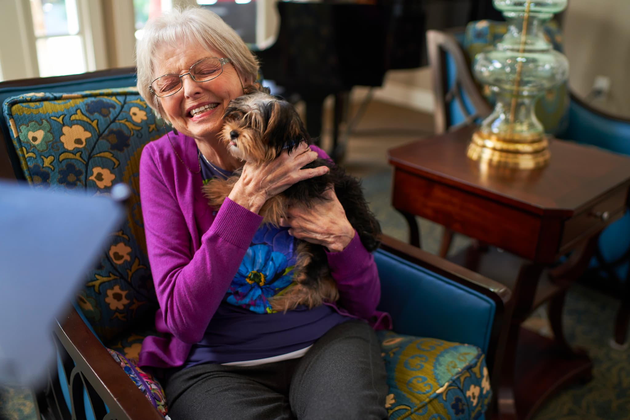 A resident holding a puppy and smiling