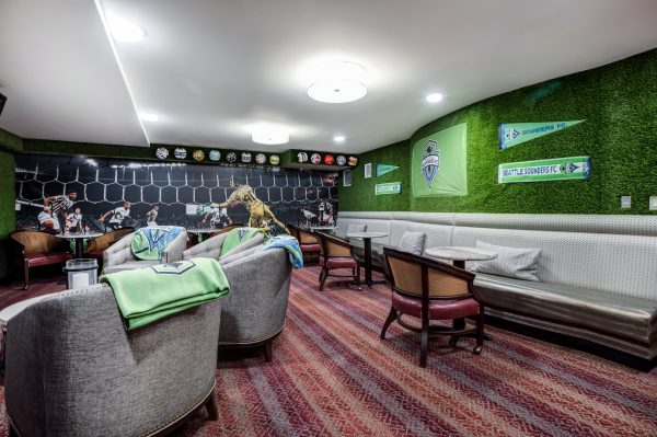 A sports-themed room with armchairs and small tables