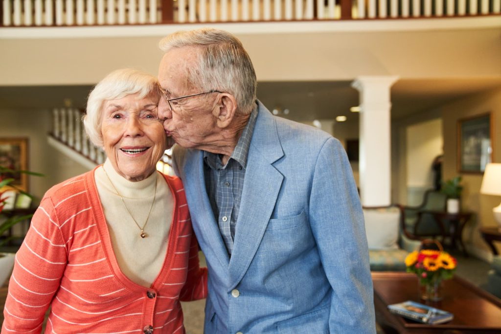 A resident kissing his wife on the cheek