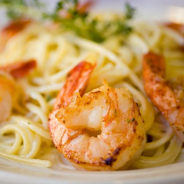 A closeup of a plate of pasta with shrimp