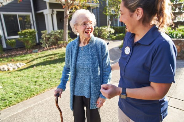 A resident happily walking with an employee