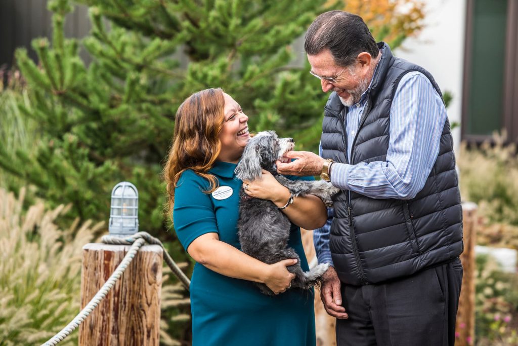 A resident talking to an employee holding a dog