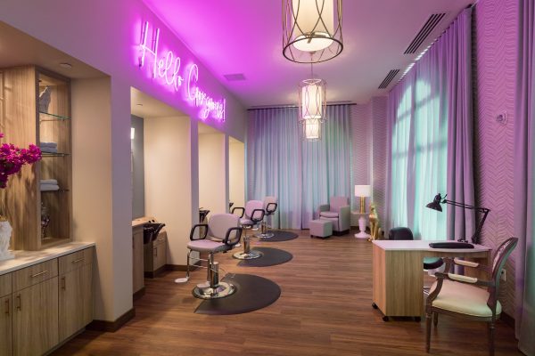 A hair salon with a fuchsia neon “Hello Gorgeous!” sign.