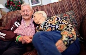 elderly couple sitting together on a couch