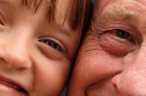 Closeup of child's face and elderly person's face side-by-side shows effects of aging on the skin