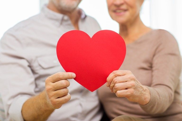 couple holding paper heart together