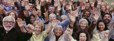 Large group of multi-ethnic people cheering with arms raised