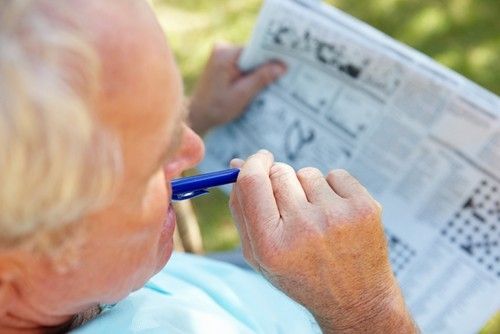 a senior man doing a crossword puzzle