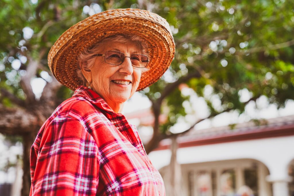 A resident smiling, wearing a hat